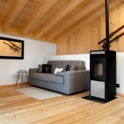 soggiorno con stufa a pellet chalet Nido Verde per vacanze in inverno