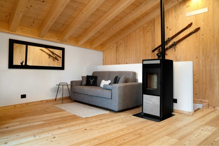soggiorno con stufa a pellet chalet Nido Verde per vacanze in inverno